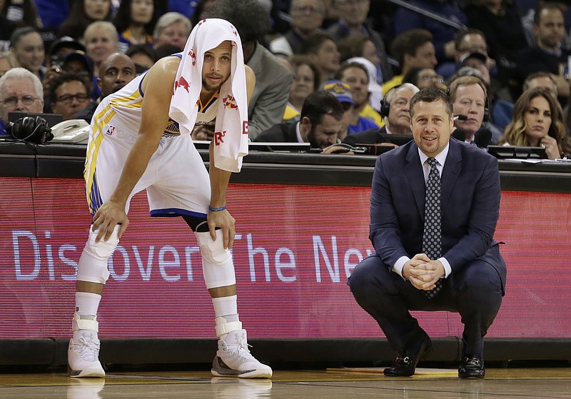 
              Golden State Warriors' Stephen Curry, left, watches the second half of an NBA basketball game beside Sacramento Kings coach Dave Joerger, Friday, March 24, 2017, in Oakland, Calif. (AP Photo/Ben Margot)
            