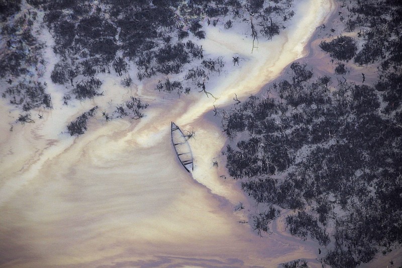 
              FILE- In this Thursday, March 24, 2011 file photo, oil flows on the creek water's surface near an illegal oil refinery in Ogoniland, outside Port Harcourt, in Nigeria's Delta region. Royal Dutch Shell's Nigeria subsidiary "fiercely opposed" environmental testing and is concealing data showing thousands of Nigerians are exposed to health hazards from a stalled cleanup of the worst oil spills in the West African nation's history, according to a German geologist contracted by the Dutch-British multinational. (AP Photo/Sunday Alamba, File)
            