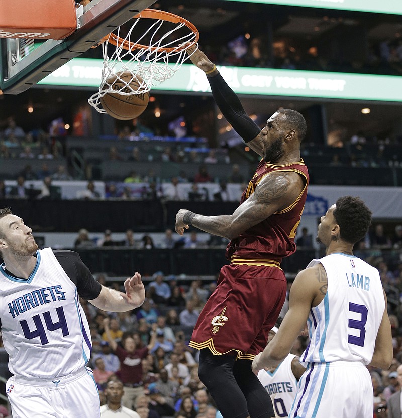 
              Cleveland Cavaliers' LeBron James dunks against Charlotte Hornets' Jeremy Lamb, right, and Frank Kaminsky, left, during the second half of an NBA basketball game in Charlotte, N.C., Friday, March 24, 2017. The Cavaliers won 112-105. (AP Photo/Chuck Burton)
            