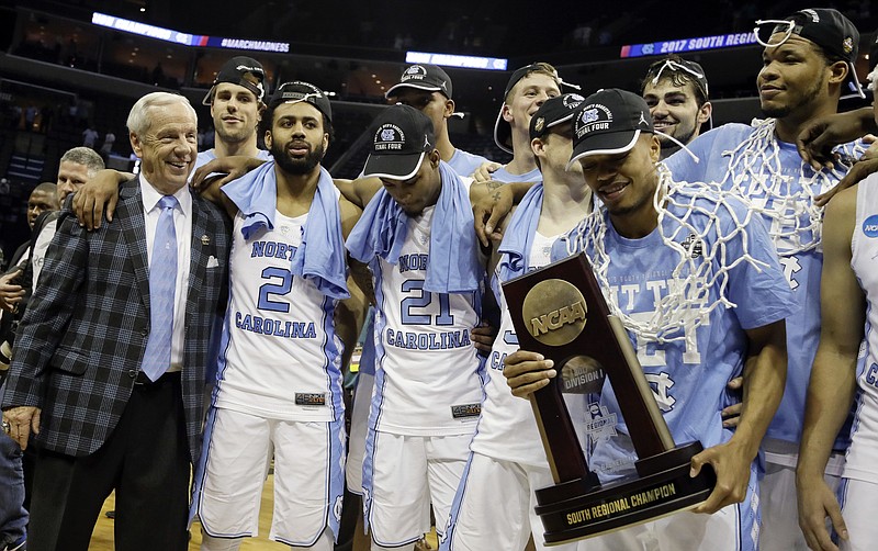 North Carolina head coach Roy Williams, left, celebrates with his players after they beat Kentucky 75-73 in the South Regional final game in the NCAA college basketball tournament Sunday, March 26, 2017, in Memphis, Tenn. (AP Photo/Mark Humphrey)