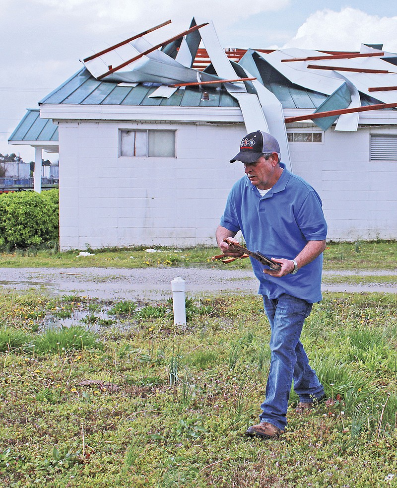 
              Gary Mask, a member of Victory Lighthouse Pentecostal, picks up debris around the church after Friday night's storm in Jonesboro, Ark., Saturday, March 25, 2017. (Staci Vandagriff/The Jonesboro Sun via AP)
            