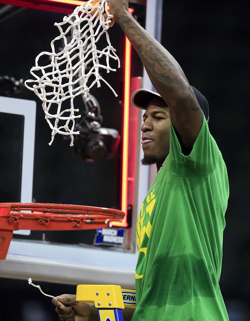 
              Oregon forward Jordan Bell cuts down the net after the team's Midwest Regional final against Kansas in the NCAA men's college basketball tournament, Saturday, March 25, 2017, in Kansas City, Mo. Oregon won 74-60. (AP Photo/Orlin Wagner)
            