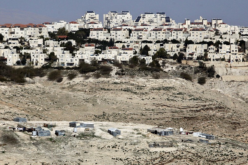 
              FILE -- In this Jan. 22, 2017 file photo, the Israeli settlement of Maaleh Adumim looms over Arab Bedouin shacks in the West Bank, Sunday, Jan. 22, 2017. Yaakov Katz, a prominent West Bank settler, said Sunday, March 26, 2017, that the number of Israelis living in the West Bank has soared by nearly one quarter over the past five years to over 420,000 people. Katz says the rapid growth means the internationally backed idea of a two-state solution between Israel and the Palestinians is now impossible. (AP Photo/Mahmoud Illean, File)
            