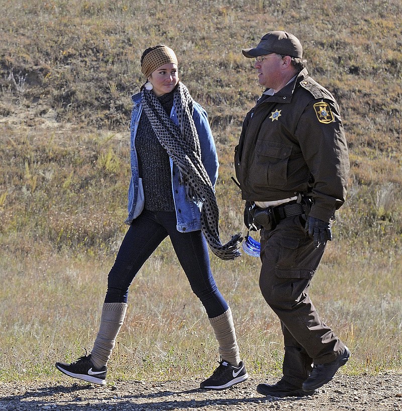 
              FILE - In this Oct. 10, 2016, file photo, actress Shailene Woodley, left, is led to a transport vehicle by a Morton County Sheriff's deputy after being arrested at a protest against the Dakota Access pipeline near St. Anthony, N.D. Woodley reached a plea deal Friday, March 24, 2017, over her involvement in protests against the oil pipeline that calls for no jail time. (Tom Stromme/The Bismarck Tribune via AP, File)
            