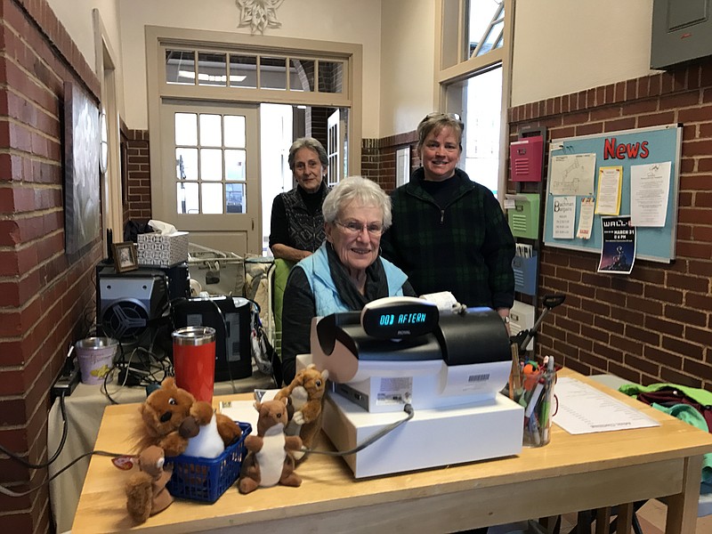 Longtime Bachman Bargains volunteers stand by the resale shop's register, adorned with squirrels in honor of the Bachman mascot. From left are Maxine Wiggins, Midge Strelow and Julia Hall.