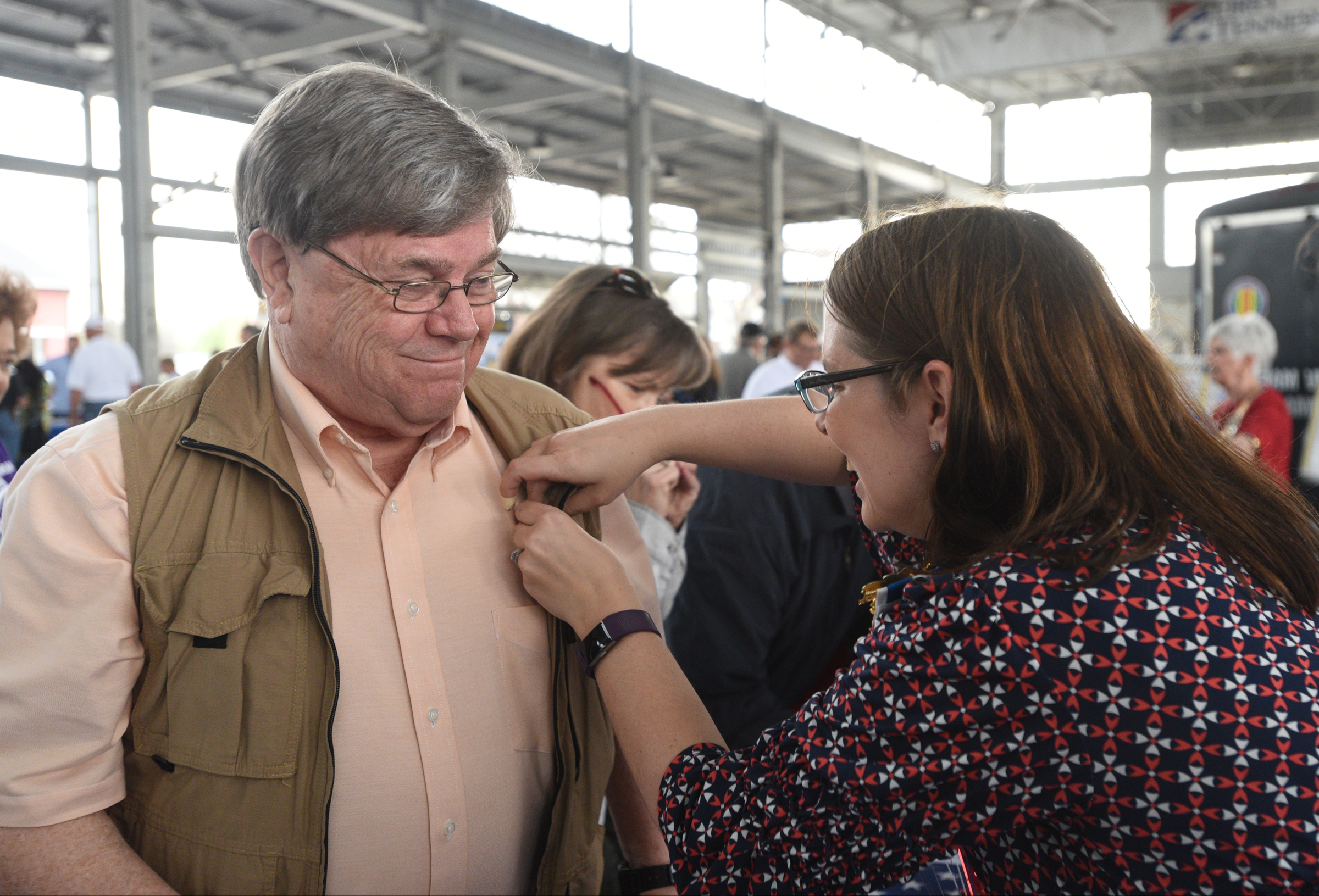 Jessica Mines Dumitru gives a pin to Mike Hillis Monday, March 27, 2017 during a Welcome Home celebration for Vietnam veterans at the First Tennessee Pavilion.