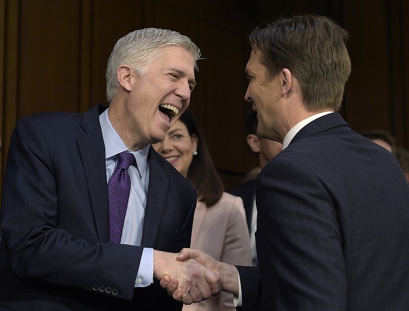 
              In this March 21, 2017 photo, Supreme Court Justice nominee Neil Gorsuch, left, shares a laugh with Senate Judiciary Committee member Sen. Ben Sasse, R-Neb.as he arrives on Capitol Hill in Washington, for his confirmation hearing before the Senate Judiciary Committee. Former New Hampshire Sen. Kelly Ayotte is at center. (AP Photo/Susan Walsh)
            
