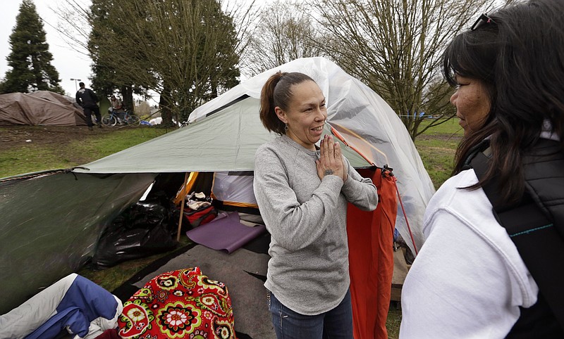 
              In this photo taken Thursday, March 23, 2017, Sheryl, left, a homeless woman who declined to give her last name, talks with outreach worker Brenda Frazier, as part of a new team of outreach workers and police officers that go out and connect homeless people to services in Seattle. Sheryl said she has lived in a tent in a greenbelt near Interstate Highway 90 for about six months. (AP Photo/Elaine Thompson)
            