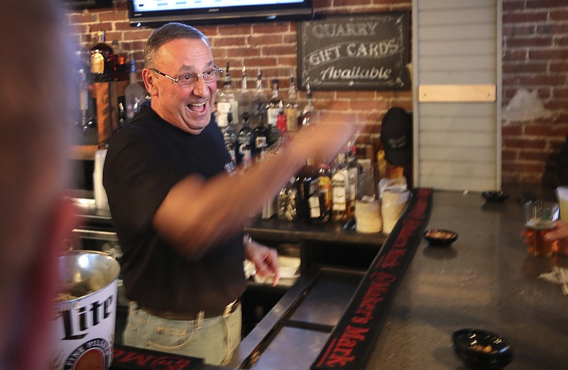 
              Maine Gov. Paul LePage takes an order while tending bar at the Quarry Tap Room in Hallowell, Maine, Monday, March 27, 2017. LePage was the celebrity bartender to benefit a foundation set up by quadruple amputee Travis Mills to help fellow military veterans. (AP Photo/Robert F. Bukaty)
            