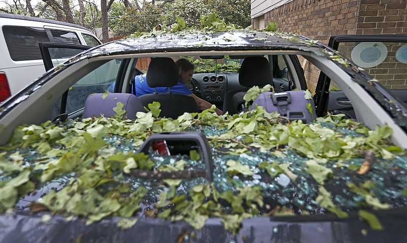 
              Tara Shadoan takes her belongings before the insurance company tows her car damaged by last night's hailstorm in Highland Village, Texas, Monday, March 27, 2017. The springtime severe weather season is ramping up with damaging winds, large hail and tornadoes in the forecast nearly every day this week, including in parts of Kentucky, Mississippi and Tennessee on Monday. A day earlier, the same storm system swept through parts of Oklahoma and Texas, dropping softball-sized hailstones near Dallas. (Jae S. Lee/The Dallas Morning News via AP)
            