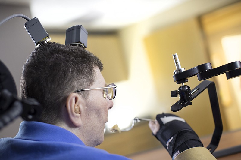 
              In this undated photo made available on Tuesday, March 28, 2017 by Case Western Reserve University, Bill Kochevar feeds himself, in Cleveland, Ohio. A paralyzed man was able to feed himself for the first time in eight years, after doctors implanted electronic sensors into his brain and arm that restored the broken connection between them. Kochevar, 56, was paralyzed from the shoulders down after a cycling accident in Cleveland nearly a decade ago. (Russell Lee/ Case Western Reserve University via AP)
            