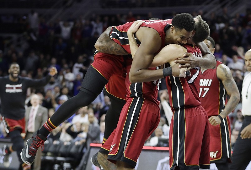 
              Miami Heat center Hassan Whiteside is greeted by Goran Dragic (7) while lifted by teammate James Johnson after his last second shot to beat the Detroit Pistons 97-96 during the second half of an NBA basketball game, Tuesday, March 28, 2017, in Auburn Hills, Mich. (AP Photo/Carlos Osorio)
            