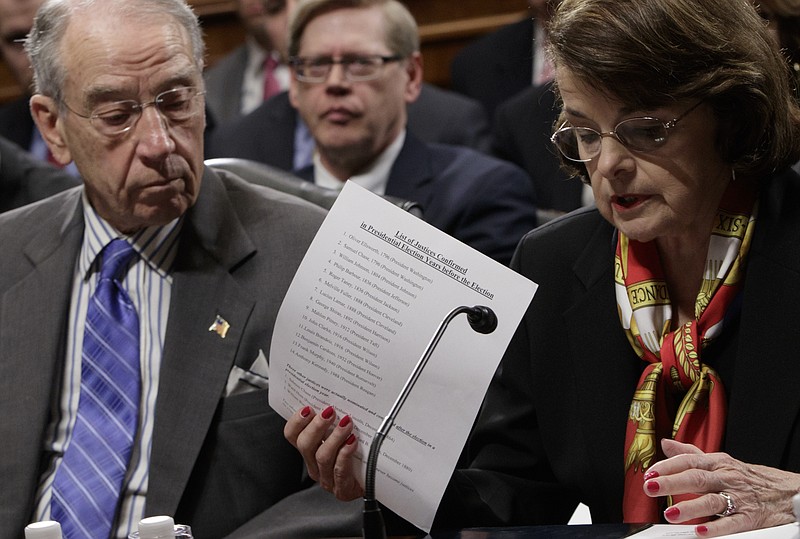 
              Senate Judiciary Committee Chairman Sen. Charles Grassley, R-Iowa, center, listens as the committee's ranking member, Sen. Dianne Feinstein, D-Calif. requests a one week postponement for the panel to vote on Supreme Court nominee Neil Gorsuch, as she displays a list of appointments made during presidential election years, Monday, March 27, 2017, on Capitol Hill in Washington. (AP Photo/J. Scott Applewhite)
            