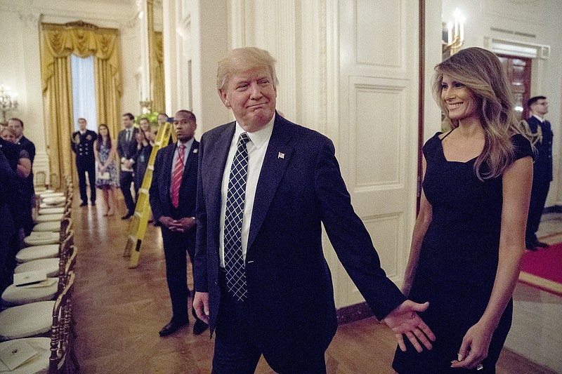 
              President Donald Trump and first lady Melania Trump arrive for a reception for Senators and their spouses in the East Room of the White House, Tuesday, March 28, 2017, in Washington. (AP Photo/Andrew Harnik)
            