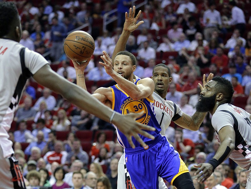
              Golden State Warriors' Stephen Curry (30) dishes the ball between Houston Rockets' Clint Capela, Trevor Ariza (1) and James Harden (13) in the first half of an NBA basketball game in Houston, Sunday, March 28, 2017. (AP Photo/Michael Wyke)
            