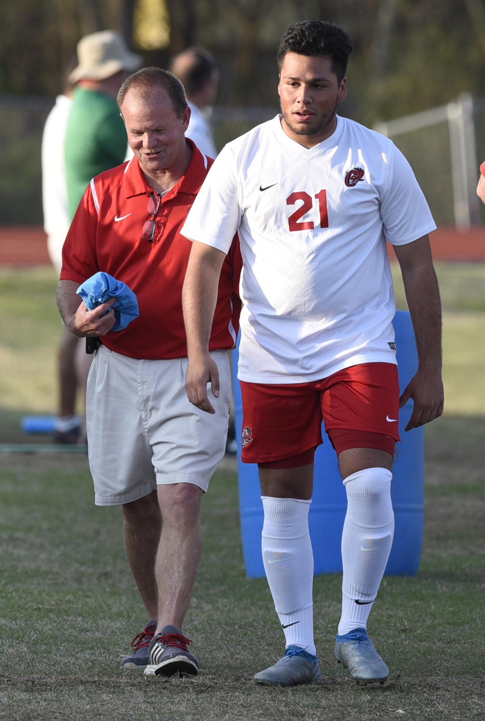 Ooltewah coach Rick Adolph consoles Francis Revollo (21) after Revollo received a penalty card. The East Hamilton Hurricanes visited the Ooltewah Owls in boys TSSAA soccer action on March 29, 2017.