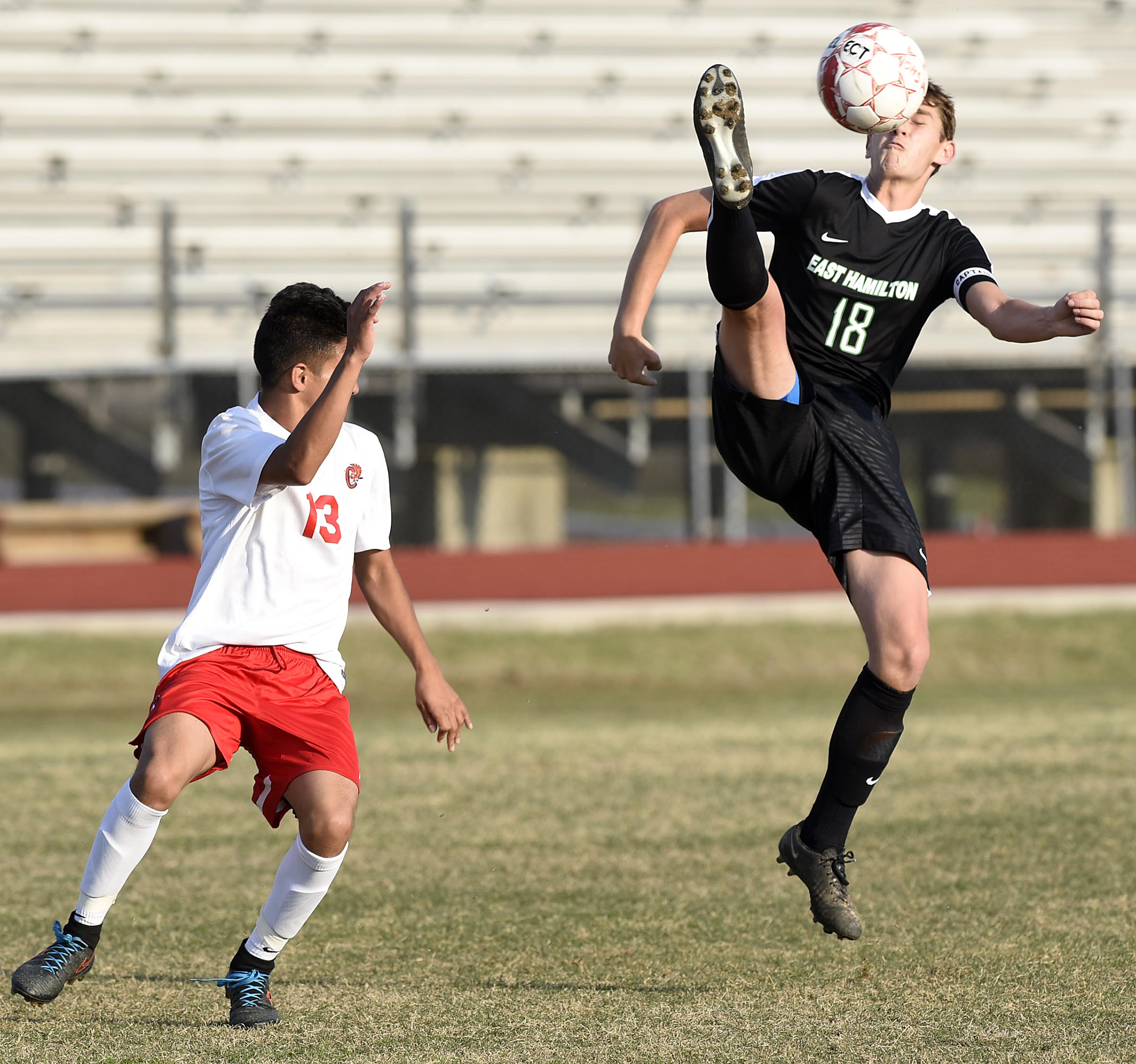 East Hamilton Daniel Walsh (18) goes high for a kick as Ooltewah's Darwin Martinez (13) defends. The East Hamilton Hurricanes visited the Ooltewah Owls in boys TSSAA soccer action on March 29, 2017.