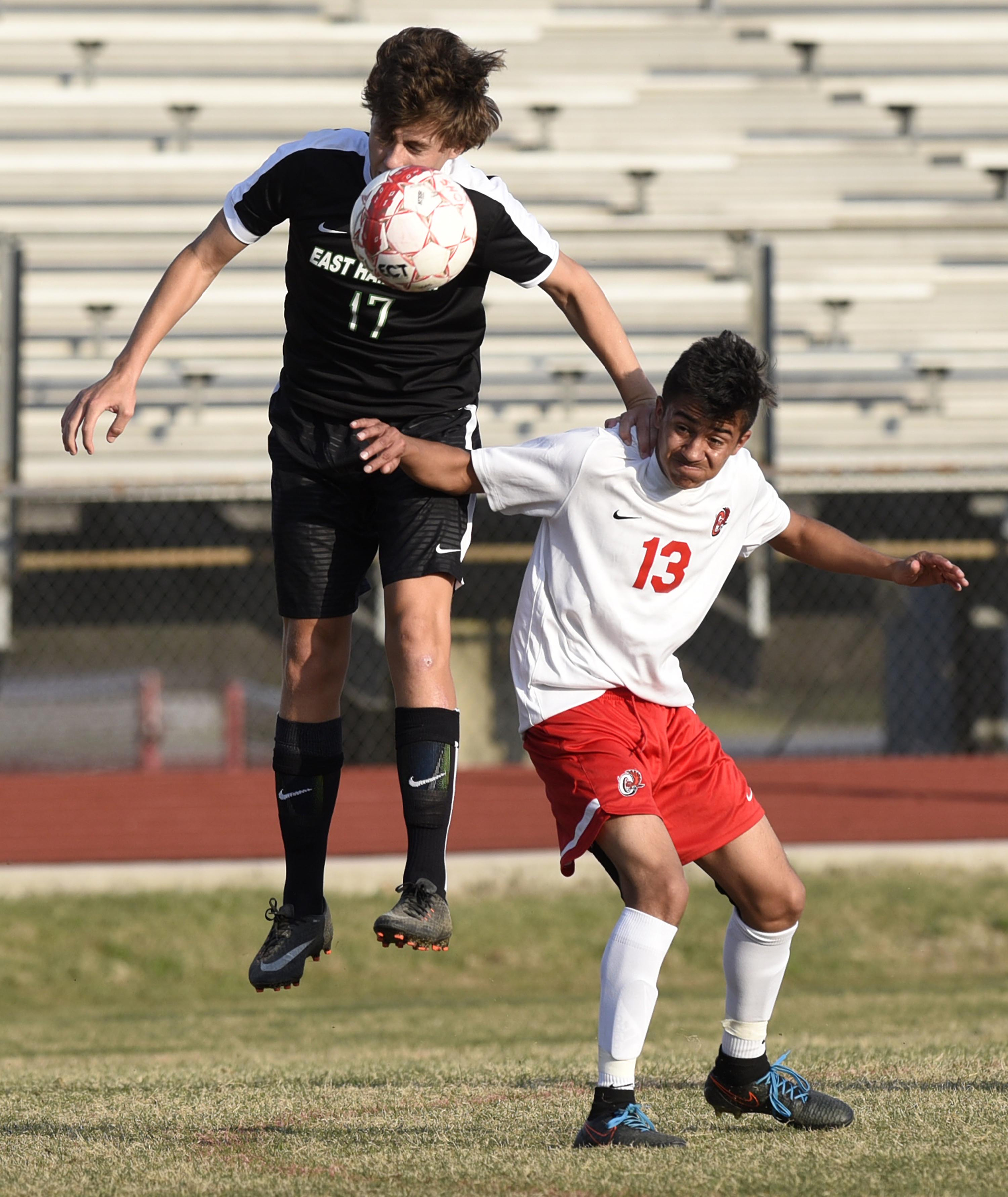 East Hamilton's T.J. Christenson (17) uses Ooltewah's Darwin Martinez (13) for leverage as he heads the ball to the ground. The East Hamilton Hurricanes visited the Ooltewah Owls in boys TSSAA soccer action on March 29, 2017.
