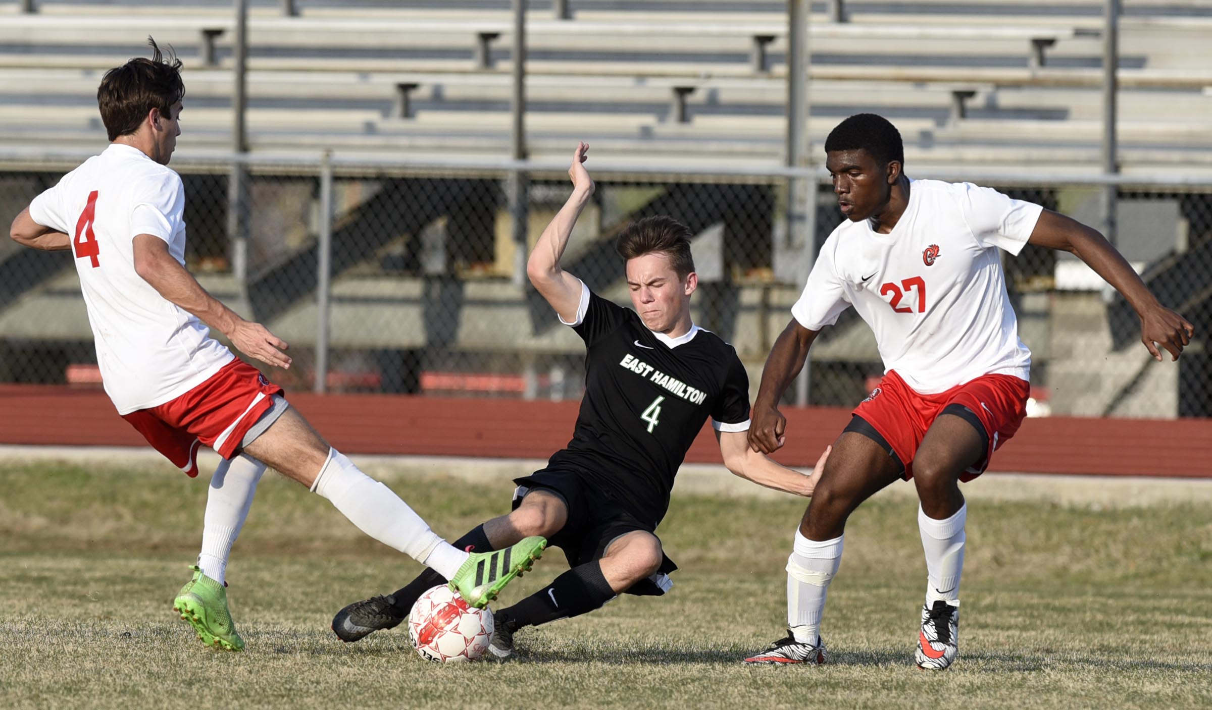 East Hamilton's Carter Carson (4) tries to thread the ball between Ooltewah's Garen Miller (4) and Stephen Turman (27). The East Hamilton Hurricanes visited the Ooltewah Owls in boys TSSAA soccer action on March 29, 2017.