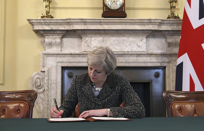 
              Britain's Prime Minister Theresa May signs the official letter to European Council President Donald Tusk, in 10 Downing Street, London, Tuesday March 28, 2017, invoking Article 50 of the bloc's key treaty, the formal start of exit negotiations. Britons voted in June to leave the bloc after four decades of membership. (Christopher Furlong/Pool Photo via AP)
            