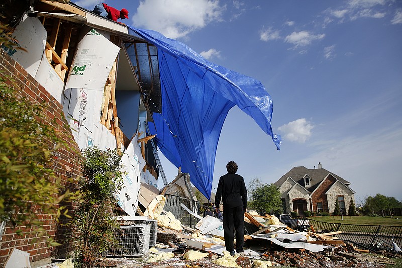 
              John Hampton stands outside his brother's house that was damaged following a storm early in the morning in Rockwall, Texas on Wednesday, March 29, 2017.  A powerful storm system with winds exceeding 60 mph has damaged homes in suburban Dallas, knocked out power to tens of thousands across Texas and brought heavy rain that inundated some areas. (Rose Baca/The Dallas Morning News via AP)
            