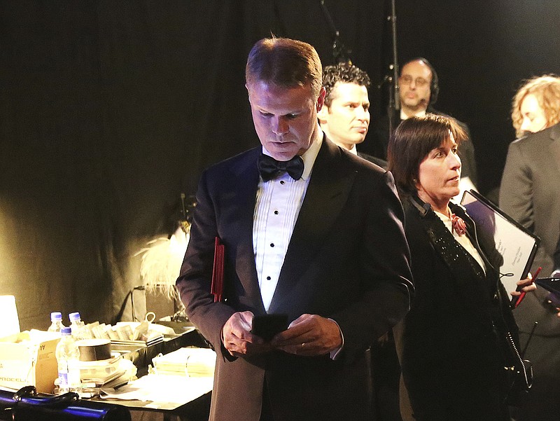 
              FILE - In this Feb. 26, 2017, file photo, PwC accountant Brian Cullinan, center, holds red envelopes under his arm while using his cell phone backstage at the Oscars at the Dolby Theatre in Los Angeles. PwC accountants won’t be allowed to have their cellphones backstage during future Oscar telecasts. Film academy president Cheryl Boone Isaacs sent an email to academy members Wednesday, March 29, 2017, detailing the new protocols established for announcing Oscar winners after the best-picture flub at last month’s Academy Awards. Boone Isaacs blamed Cullinan’s distraction for the error. (Photo by Matt Sayles/Invision/AP, File)
            