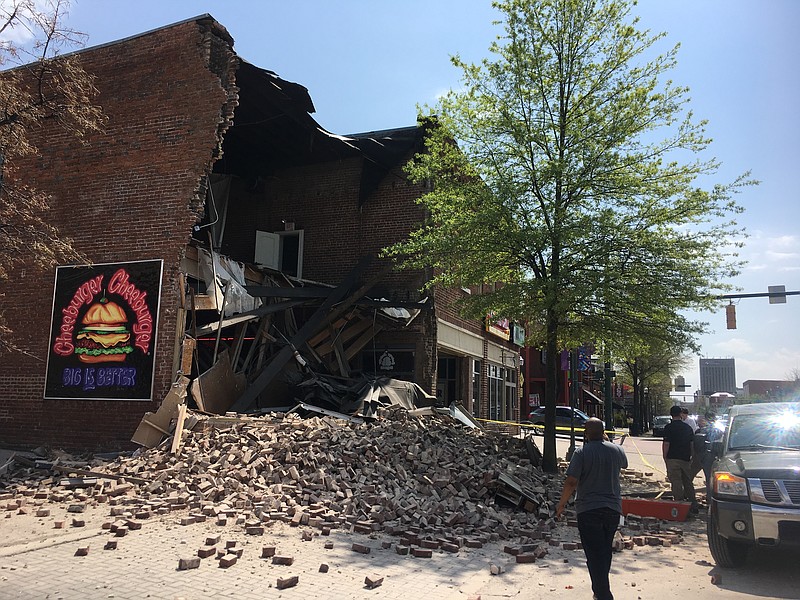 Pedestrians gather before Chattanooga emergency personnel arrive at the scene where the front of the Cheeburger Cheeburger building collapsed at the intersection of Aquarium Way and Market Street on Wednesday just before 2 p.m. in downtown Chattanooga.