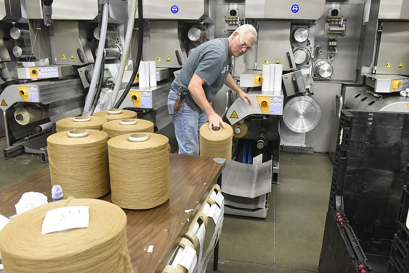 Jeff Smith unloads spools of carpet fiber from an extruder at the J + J Flooring Group facility Monday, Sept. 28, 2015, in Dalton, Ga. 