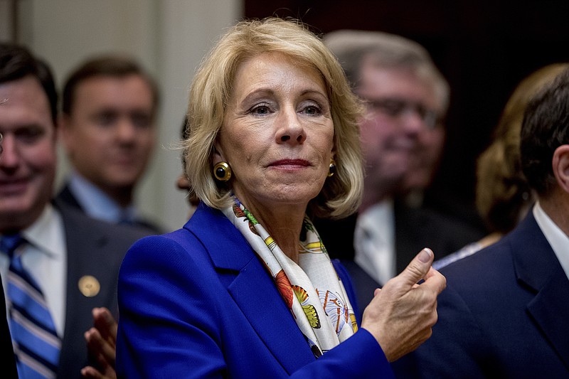 
              This photo taken Monday, March 27, 2017, shows Education Secretary Betsy DeVos waiting for President Donald Trump to arrive to sign various bills in the Roosevelt Room of the White House, in Washington. DeVos is now considering allowing students to use the grants year-round, rather than just for two semesters in any given year. (AP Photo/Andrew Harnik)
            