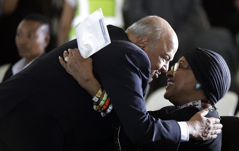 
              Pravin Gordhan, South Africa's finance minister, left, greets former President Nelson Mandela's wife, Winnie Madikizela-Mandela, during the funeral service for Ahmed Kathrada, at West Park Cemetery in Johannesburg, South Africa, Wednesday, March 29, 2017. Anti-apartheid activist Ahmed Kathrada, who spent 26 years in jail - many of them alongside Nelson Mandela - for working to end South Africa's previous white minority rule, died in Johannesburg on Tuesday morning. He was 87 years old. (AP Photo/Themba Hadebe)
            