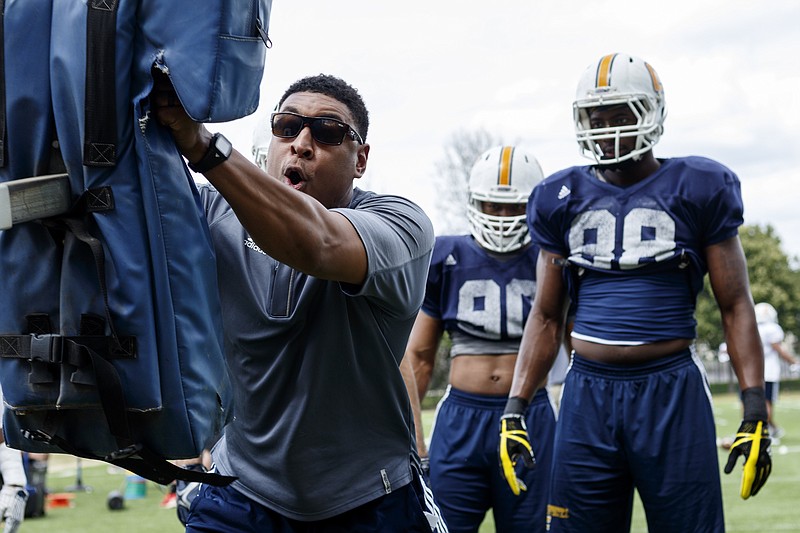 UTC outside linebackers coach Demarcus Covington demonstrates a drill during a practice at Scrappy Moore Field.