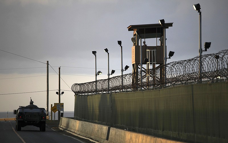 
              FILE – In this March 30, 2010, file photo, reviewed by the U.S. military, a U.S. trooper stands in the turret of a vehicle with a machine gun, left, as a guard looks out from a tower at the detention facility of Guantanamo Bay U.S. Naval Base in Cuba. A federal appeals court won't order the government to release graphic videos of a former Guantanamo Bay inmate being force-fed during a hunger strike.  (AP Photo/Brennan Linsley, File)
            