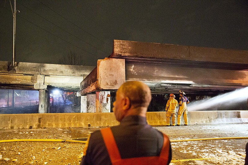 
              Firefighters survey the section of an overpass that collapsed from a large fire on Interstate 85 in Atlanta, Thursday, March 30, 2017. Atlanta officials say a massive fire that burned for more than an hour caused the collapse of the interstate overpass. Georgia Gov. Nathan Deal has issued a state of emergency for the county. (AP Photo/David Goldman)
            