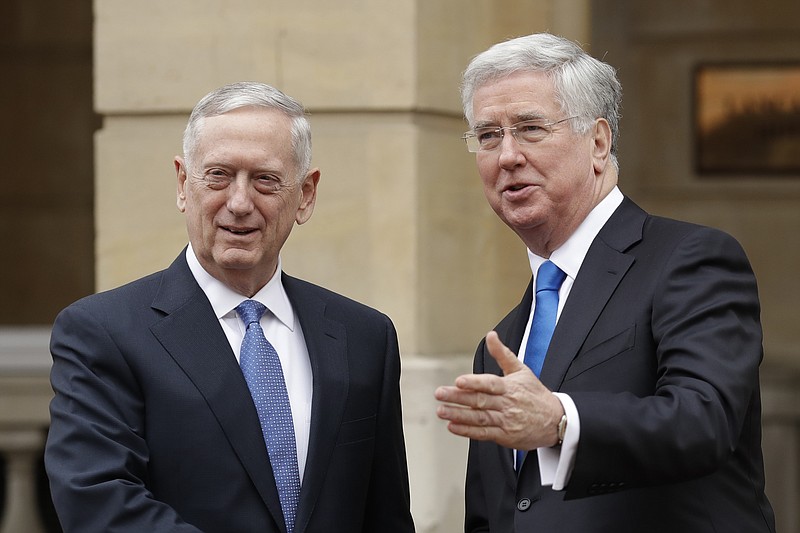 
              U.S. Defense Secretary James Mattis, left, and British Defence Secretary Michael Fallon perform a posed handshake for the media as Mattis arrives for their press conference at Lancaster House in London, Friday, March 31, 2017. (AP Photo/Matt Dunham, Pool)
            