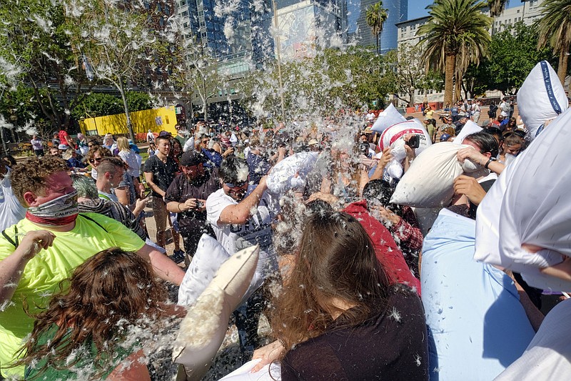 
              Feathers fly as participants take part in a giant pillow fight in Pershing Square in downtown Los Angeles on Saturday, April 1, 2017. Hundreds of people traded soft blows in in a giant pillow fight that dwarfed even the biggest slumber party slugfests. Children, teens, adults and seniors swung pillows at one another for over an hour on Saturday. The annual event is held to celebrate International Pillow Fight Day. (AP Photo/Richard Vogel)
            