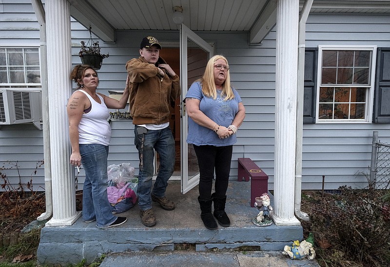 
              In this Dec. 9, 2016, photo, Zaine Pulliam, center, stands by family friend Jewels Hudson, left, and his grandmother Madie Clark at his family home in South Charleston, W.Va. Zaine and his two sisters lost their parents to heroin overdoses. The family lives in a rural West Virginia area where drug overdoses are on the rise.  (Bonnie Jo Mount/The Washington Post via AP)
            