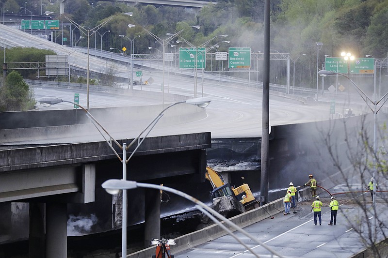 
              Crews work on a section of an overpass that collapsed from a large fire on Interstate 85 in Atlanta, Friday, March 31, 2017. Many commuters in some of Atlanta's densely populated northern suburbs will have to find alternate routes or ride public transit for the foreseeable future after a massive fire caused a bridge on Interstate 85 to collapse Thursday, completely shutting down the heavily traveled highway. (AP Photo/David Goldman)
            