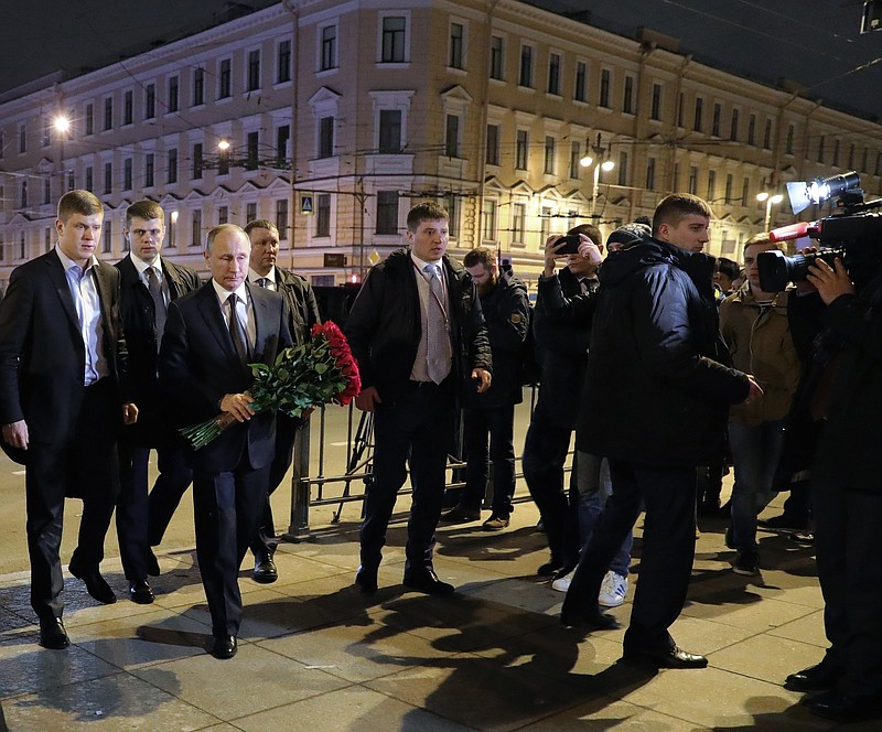 Russian President Vladimir Putin, third left, lays flowers at a place near the Tekhnologichesky Institute subway station in St. Petersburg, Russia, Monday, April 3, 2017. A bomb blast tore through a subway train deep under Russia's second-largest city Monday, killing several people and wounding many more in a chaotic scene that left victims sprawled on a smoky platform. (Mikhail Klimentyev/Pool Photo via AP)