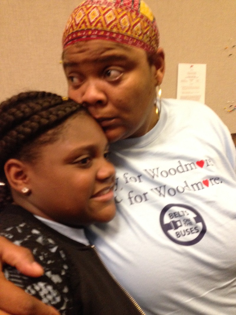 5th grader Canasia Williams, who survived last year's deadly Woodmore Elementary School bus crash, hugs her grandmother, Selbrea Rhodes, Tuesday after mandatory bus seat-belt bill clears House panel.