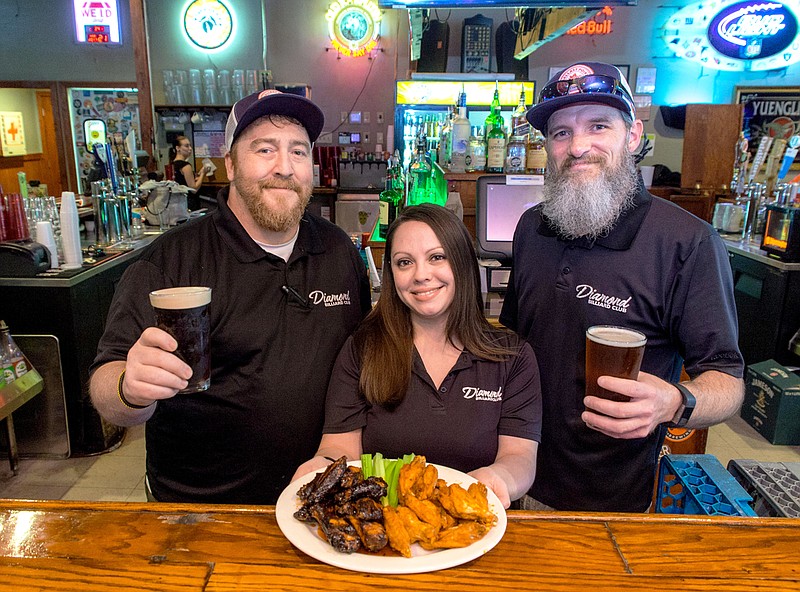 Jesse Howard, Julia Askew and Heston Mercer stand with their famous wings behind the bar at Diamond Billiard Club. (Photo By Mark Gilliland)
