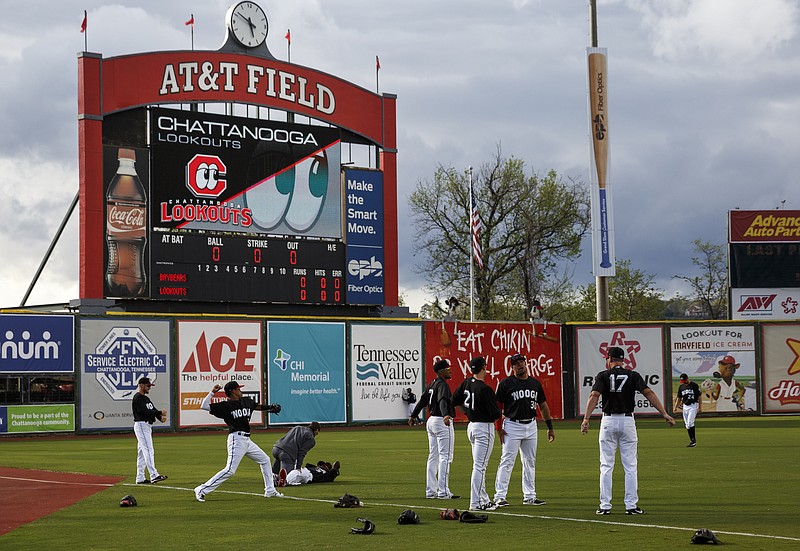 Lookouts players warm up in front of a new jumbo scoreboard screen before the Lookouts' season opener against the Mobile Bay Bears at AT&T Field on Thursday, April 6, 2017, in Chattanooga, Tenn