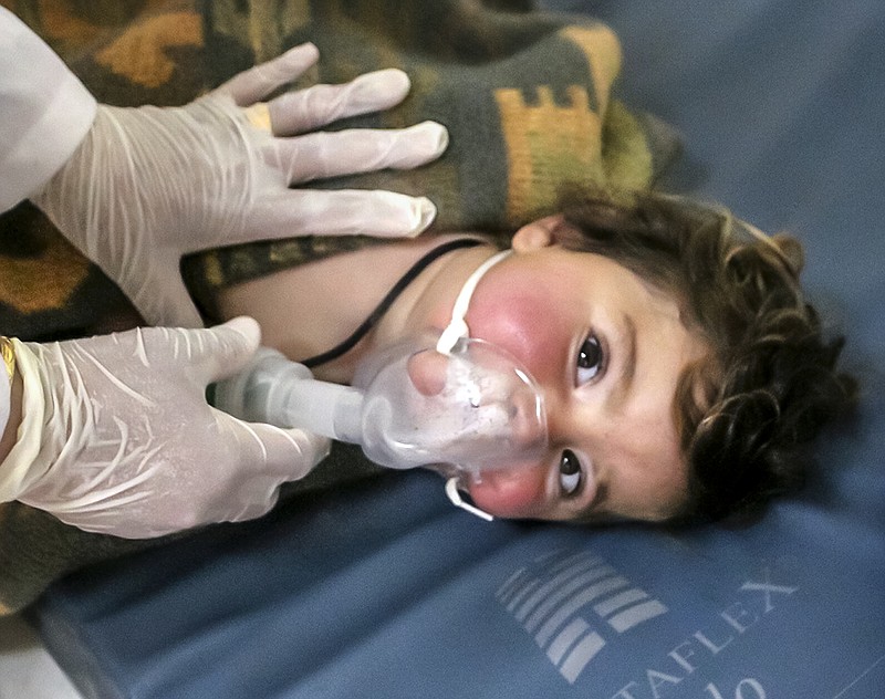 This photo provided Tuesday, April 4, 2017 by the Syrian anti-government activist group Edlib Media Center, which has been authenticated based on its contents and other AP reporting, shows a Syrian doctor treating a child following a suspected chemical attack, at a makeshift hospital, in the town of Khan Sheikhoun, northern Idlib province, Syria. The suspected chemical attack killed dozens of people on Tuesday, Syrian opposition activists said, describing the attack as among the worst in the country's six-year civil war. (Edlib Media Center, via AP)