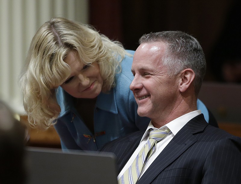 
              State Sen. Anthony Canella, R-Ceres, smiles as he talks with Sen. Cathleen Galgiani, D-Stockton, as lawmakers debate a transportation bill, that would increase the state's gas and vehicle taxes $5 billion-a-year- to pay for major road repairs, Thursday, April 6, 2017, in Sacramento, Calif. Cannella joined Democrats in voting for the bill, SB1, that was approved and sent to the Assembly. (AP Photo/Rich Pedroncelli)
            