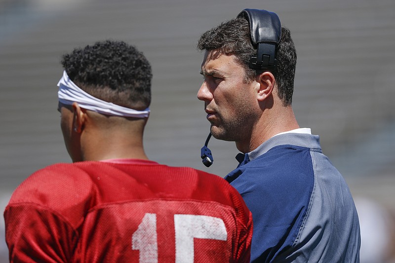 UTC head football coach Tom Arth, right, talks with quarterback Alejandro Bennifield during UTC's spring football game day at Finley Stadium on Saturday, April 8, 2017, in Chattanooga, Tenn. This year's spring game was an open practice followed by a 40 minute scrimmage.