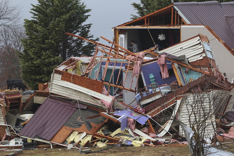 Staff Photo by Dan Henry / The Chattanooga Times Free Press- 11/30/16. Jackie Allday (top floor) helps her friend Kaylan Brown scavenge for clothing in whats left of the Brown's residence after a suspected tornado destroyed the Ider, AL., home on Wednesday, Nov 30, 2016. The overnight storm destroyed Sand Mountain structures and killed three people in the neighboring town of Rosalie, AL. 