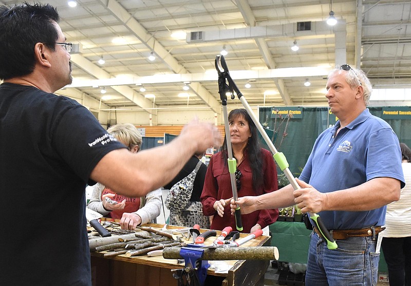Duane Burton, left, of Iron Wood Tools talks to Jackie Culp And Dennis Small, of Sweetwater, Tenn., about the flexibility of pruning shears.  The 5th Annual Master Your Garden Garden Expo was held at the Camp Jordan Arena on April 9, 2017.  