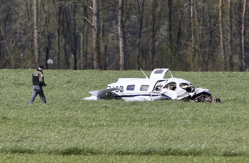 
              A Linn County Sheriff deputy approaches the scene of a small plane crash north of Harrisburg, Ore., that left four people dead, Friday April 7, 2017. (Collin Andrew/The Register-Guard via AP)
            