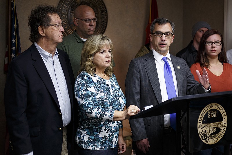 David Goetcheus, father of Sean and Donny Goetcheus, left, and their stepmother Julenne, center, listen as District Attorney Neal Pinkston speaks during a news conference at the Cold Case Unit offices to announce the resolution of the 19-year-old cold case of the murders of the two brothers held on Tuesday, Oct. 25, 2016, in Chattanooga. Christopher Jeffre Johnson, 52, was indicted Monday by the Hamilton County Grand Jury on 2 counts of first-degree murder in the 1997 slaying.