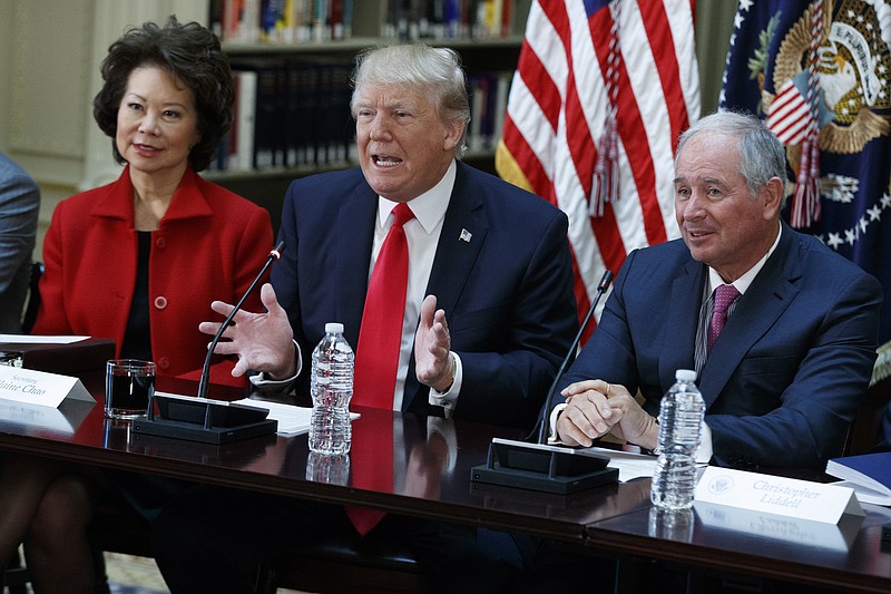 
              President Donald Trump, flanked by Transportation Secretary Elaine Chao, left, and Blackstone Group CEO Stephen Schwarzman, speaks during a meeting with business leaders in the State Department Library of the Eisenhower Executive Office Building on the White House complex in Washington, Tuesday, April 11, 2017. (AP Photo/Evan Vucci)
            