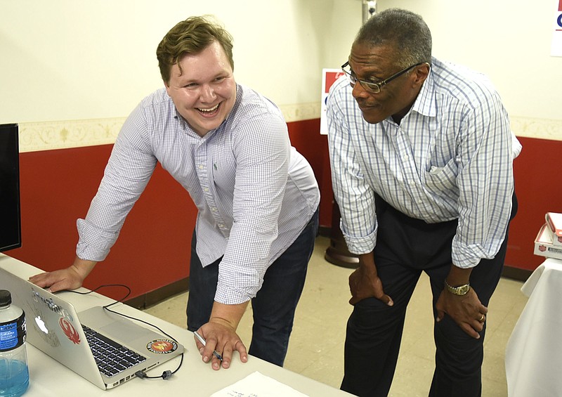 Campaign manager Dalton Temple smiles as election results for his candidate Erskine Oglesby, right, roll in at the Alton Park headquarters. Erskine Oglesby won the runoff election from District 7 on April 11, 2017. / Staff file photo